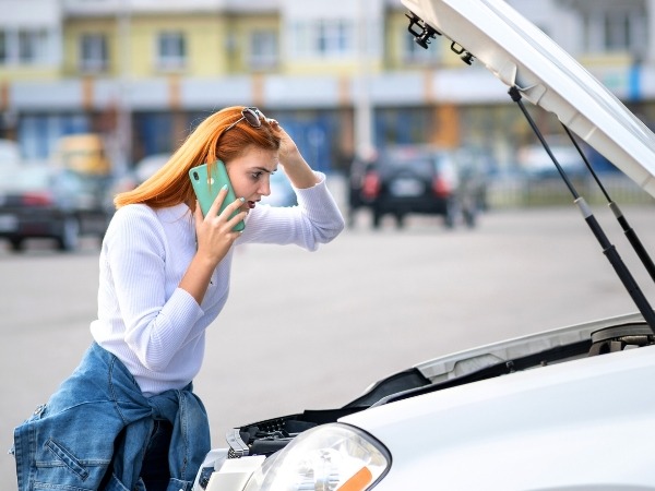 Woman Checking a Broken Down Car