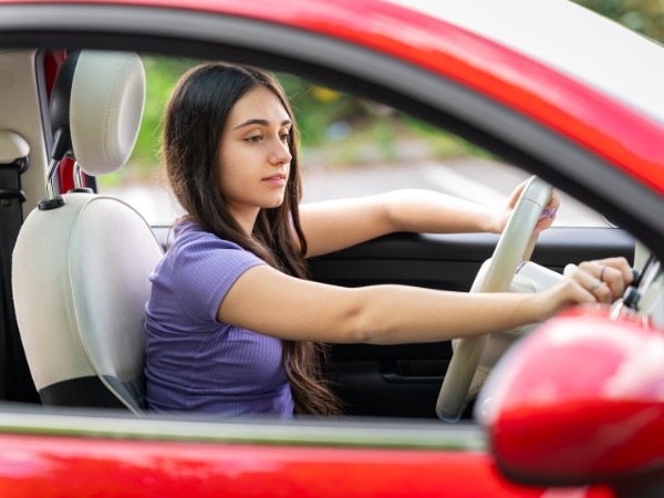 Young Woman Driving a Red Car