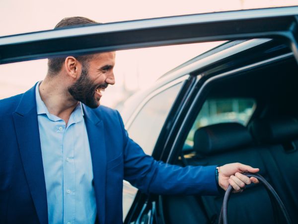 Happy Man Entering Rental Car at the Airport